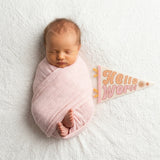 Newborn hello-world milestone photo with Flower Child pennant