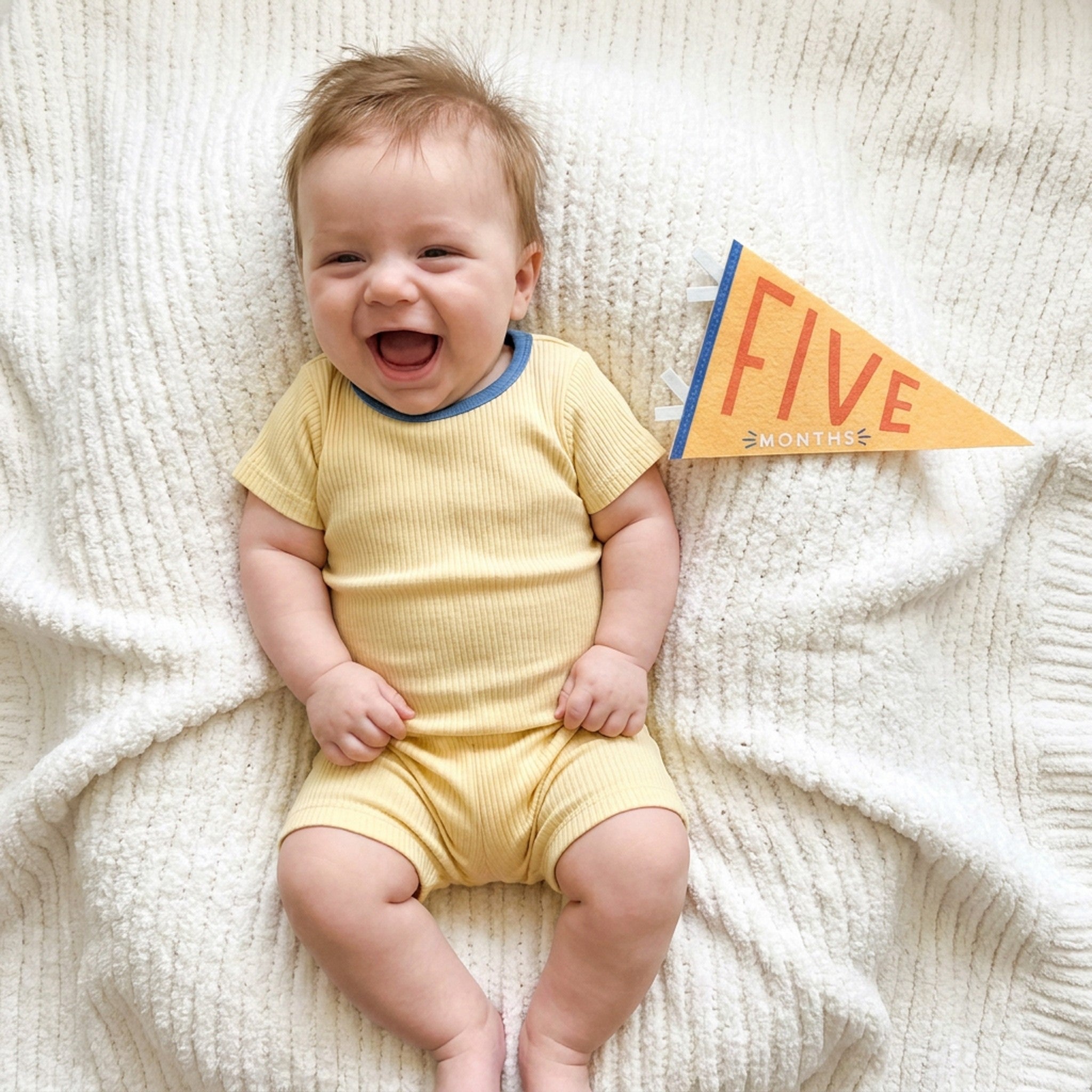 5-month milestone photo with Little Kaleidoscope pennant