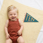 10-month milestone photo with Little Kaleidoscope pennant