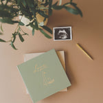Lucy Darling Pregnancy Memory Book flat lay with sage green journal, ultrasound photo, and gold pen — pregnancy keepsake